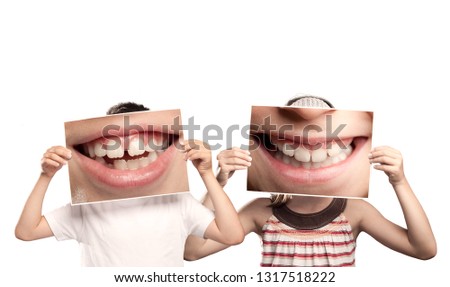 two children holding a picture of a mouth smiling isolated on white