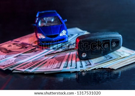 Toy car with key at dollars on black background