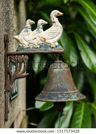 Old vintage rusty doorbell with three ducks, made of iron