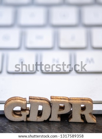 Conceptual image of wooden GDPR text with white keyboard on a table.