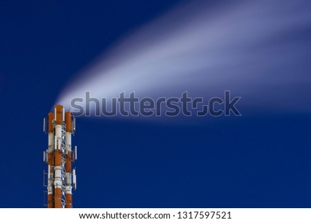 Night picture of a steaming pipe of smoking factory chimney system against a dark starry sky. Abstract Industrial Landscape