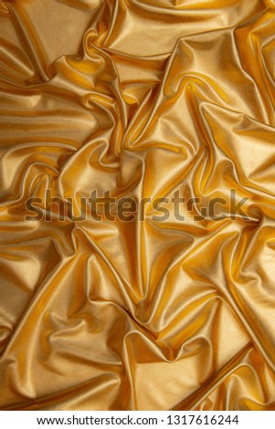 golden abstract background of luxury cloth wave,grunge lame.Texture of sheet crumled.