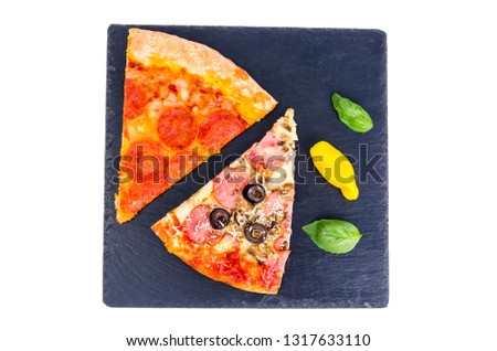 Pieces of pizza on black stone background. Studio Photo