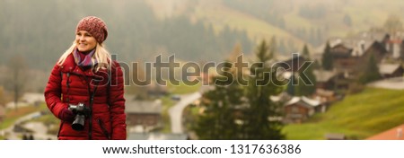 Beautiful girl photographer taking photos in the Swiss mountains. Switzerland.