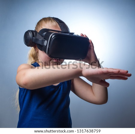 Close up image of a young toddler girl using a VR / Virtual Reality headset to look at amazing technological things