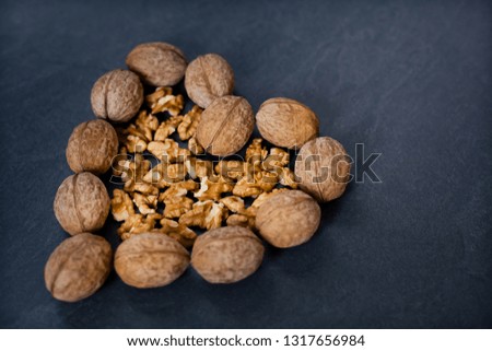 walnut on a gray background in the shape of a heart to the side

