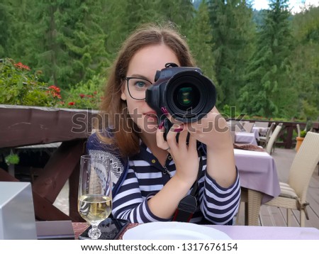 Beautiful girl recording video on camera In the open air restaurant.. Food blogger concept