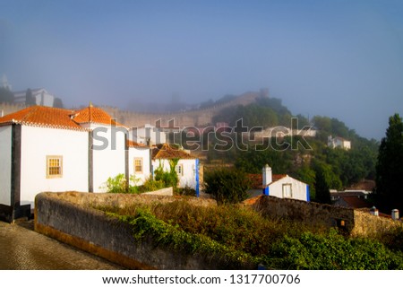 View of the old part of Obidos, Portugal in the early foggy morning