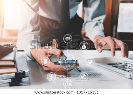 Businessman hand using smart phone,mobile payments online shopping,omni channel in modern office on wooden desk,virtual interface icons screen