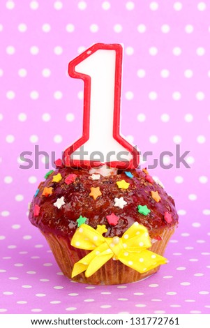 Birthday cupcake with chocolate frosting on lilac background