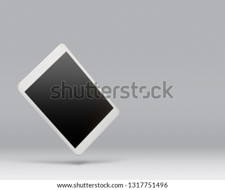 Digital tablet floating above a blank background with copy space for text. Royalty-Free Stock Photo #1317751496