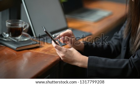 Woman using mobile smart phone on workspace 