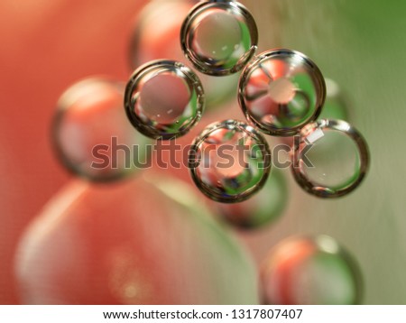 Scores of bubbles, an abstract background. Close up shot. Blurred background. Selective soft focus. Spheres glittering with green and pink lights. Abstract universe of colourful bubbles. Macro shot