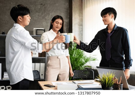 Young business partner holding coffee cup in hand,clink ceramic cup,for boots up power,sign and symbol of joining teamwork for discusse deal,at office