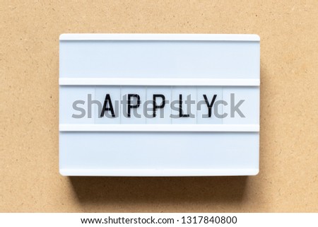 White lightbox with word apply on wood background