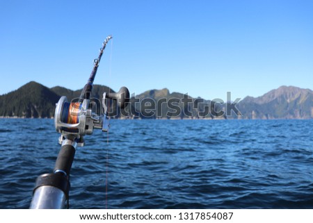 Fishing rod on boat with mountain backdrop