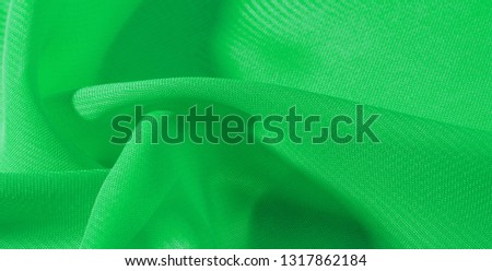 texture background pattern green silk fabric. This silk organza has a gentle open weave. Use this luxurious fabric for anything from your design for special occasions to creating your projects.
