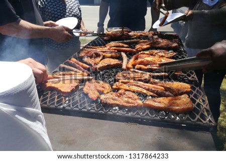 South African people braaing (cooking) meat together. Diversity concept image. 