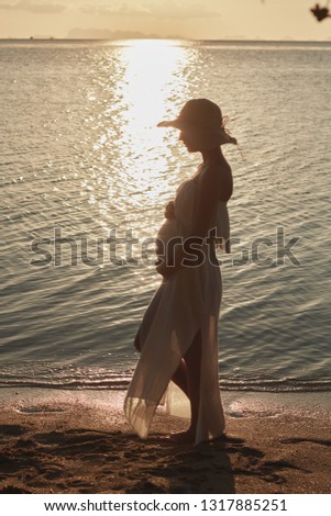 Outdoor  photo of young pregnant beautiful lady in hat. Summer Beach travel. Summer vibes