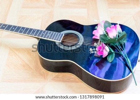 pictured in the photo Acoustic guitar laying on bed low angle shot from bottom with plectrum on the body