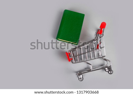 Book in a shopping cart on a gray background.