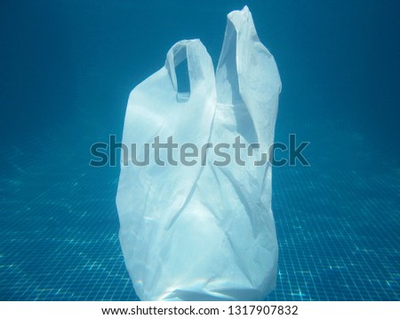 Plastic bag floating into the water. Polluted enviromental. Recycle garbage                     