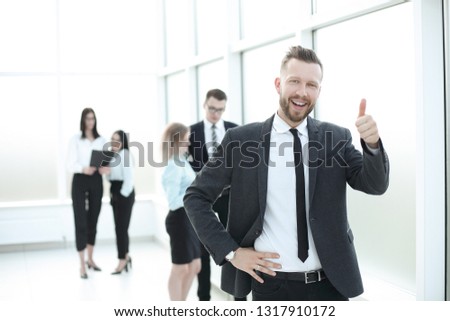 smiling successful business man showing thumb up