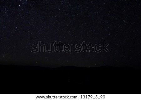 Silhouette mountain with night sky and stars in the dark night with noise and grain image