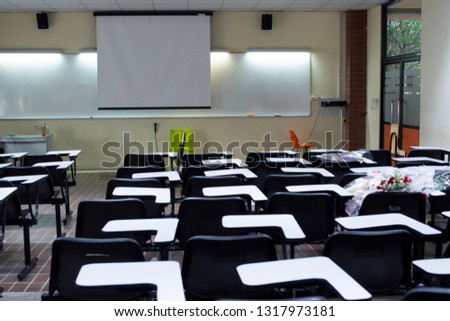 University or school black lecture chairs and white tables in classroom.