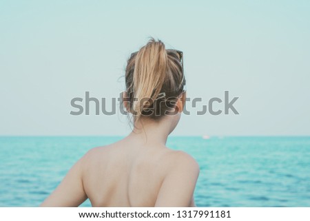 Girl looking to sea shore blue water