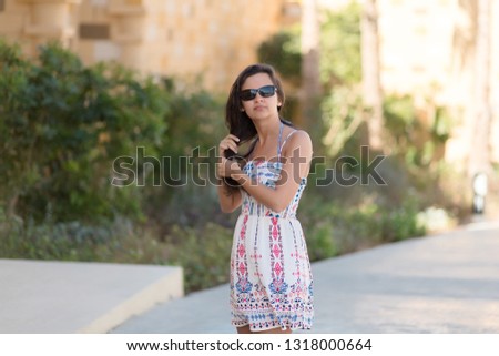 Woman in a dress is standing in the garden