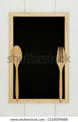 Blank chalkboard with wooden spoon and fork on white wood plank background. Styled stock photography for cookbook, food blog posts and social media content. 