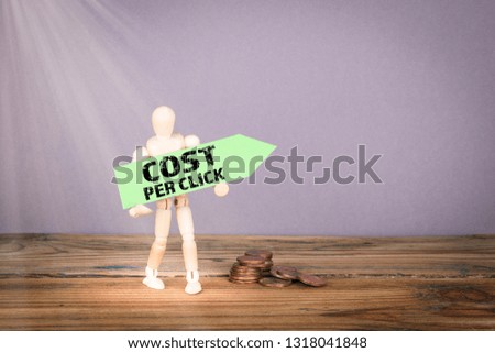 Cost Per Click concept. Wooden man with green an arrow