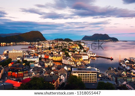 Alesund, Norway. Aerial view of Alesund, Norway at sunrise. Colorful cloudy sky over famous tourisitc destination with sunlight and mountains
