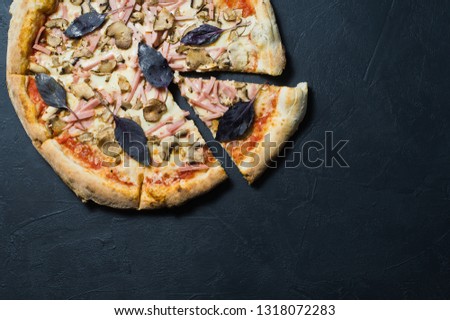 Italian pizza with ham, mushrooms and Basil. Dark background, top view, space for text