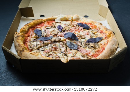 Pizza in a cardboard box, dark background. Close up. View from above. Pizza delivery. Pizza menu.