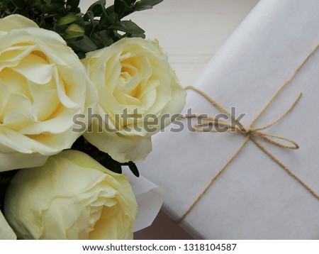 Bouquet of ivory roses and gift box.