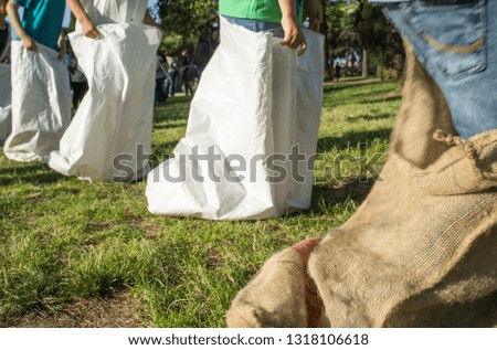 Children having a sack race in the park. Classic games concept. Motion blurred