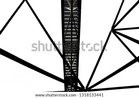 Incredible construction of the Tetrahedron in german Bottrop with stairs leading to the top of the view point captured on a black and white photography that was taken from below against the sky. 