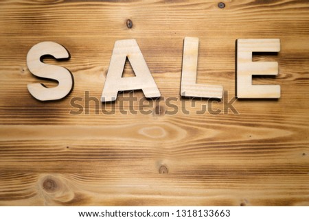 SALE word made with building blocks on wooden board