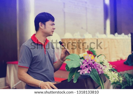 Selective focus of business man is making a speech in front of a big audience at a conference hall.