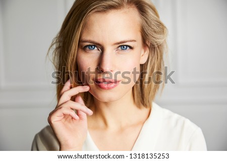 Gorgeous blue eyed blond woman looking at camera Royalty-Free Stock Photo #1318135253