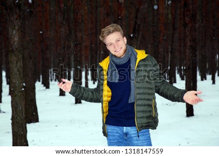 Young man posing in snowy winter forest