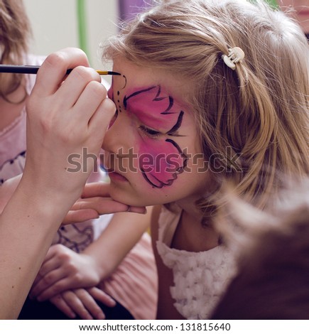little girl with faceart on birthday party Royalty-Free Stock Photo #131815640