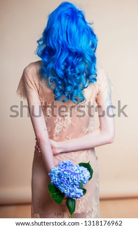 blue hair hairstyle curls girl's back bright hair color creative painting in a bright shade colorist work summer style 
hydrangea flower in hand