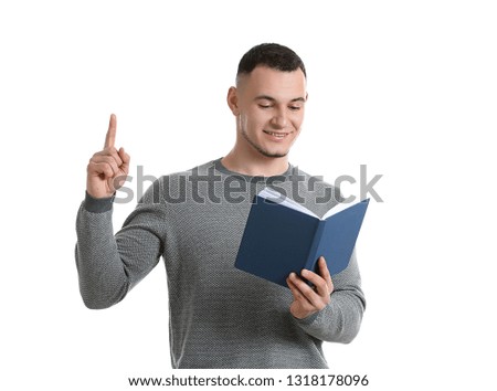 Handsome young man with book and raised index finger on white background