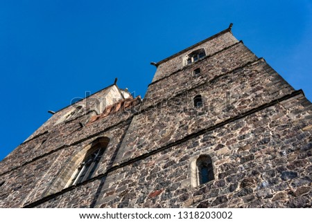 Germany, Brandenburg, Jueterbog: Front facade of famous Church of St. Nicholas (Nikolaikirche) in the city center of the German town from below with blue sky in the background - concept architecture