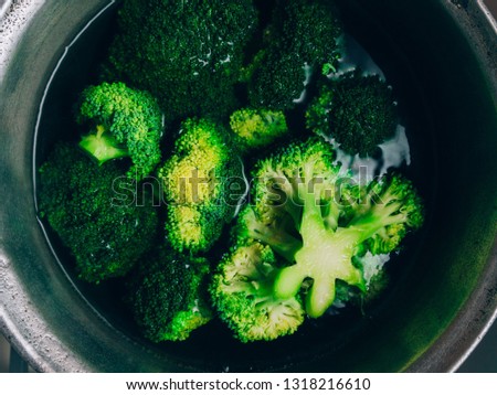 Brocolli boil in the pot. Brocolli changes its color while boiled. Closeup of healthy brocolli boiling in the water.