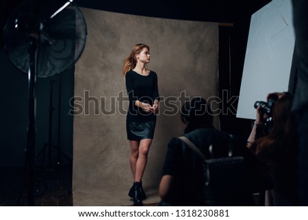 Beautiful elegant Woman in black dress on photo shoot Model Paparazzi