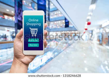Smart phone online shopping in woman hand. Shopping center in background. Buy clothes shoes accessories with e commerce web site